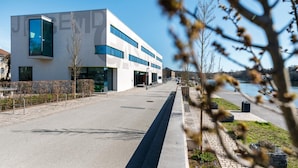 A modern building with a flat facade, large windows, and a clear sky. - Jugendherberge Schweinfurt - Hostel (Schweinfurt)