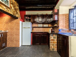 Compact kitchen with a functional design, featuring a sink, refrigerator, and tiled floor.