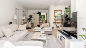 Una sala de estar moderna con sofá, mesa de centro y televisor.
