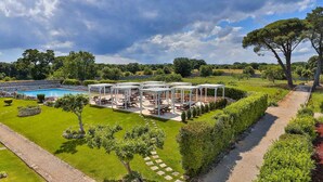 A poolside area with outdoor seating and a pergola structure.