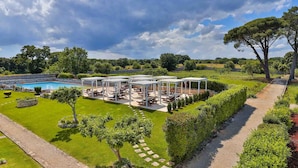 Ein Poolbereich mit Sitzgelegenheiten und einer Pergola.