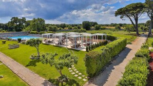 Un espace aménagé au bord de la piscine, avec des sièges extérieurs et une pergola.