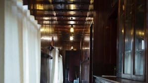 Un pasillo estrecho con paredes de madera y suelo pulido, que conduce a una puerta al final.