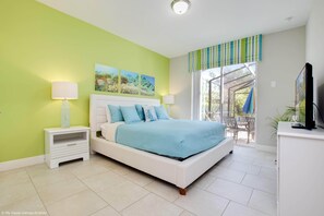 Une chambre à coucher avec un lit, des tables de chevet, une télévision et une fenêtre donnant sur un beau paysage.