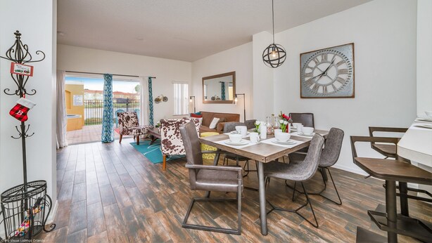 A spacious living area with a dining table, chairs, and a large clock on the wall. - Newly Renovated, Spacious 3bd/2.5ba Villa With Lake View, Near Disney #3tv709 (Kissimmee)