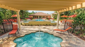 A pool area with lounge chairs and a covered section.