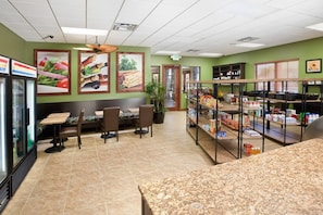 A restaurant with a green wall, a refrigerator, a counter with food items, and a seating area with chairs and tables. - Posh and Spacious Lake View Home, Only Minutes From Disney 4bd/3ba #3pp857 (Kissimmee)