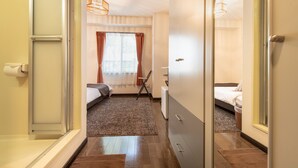 A hotel room with a bed, a desk, a chair, and a window with curtains. - Rupo Kenchoguchi Cozy Hotel (Fukuoka)