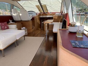 A boat interior with a sofa, a table, and a small seating area.
