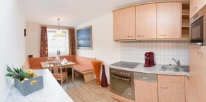 Une petite cuisine équipée avec des meubles en bois, une cuisinière et un évier.
