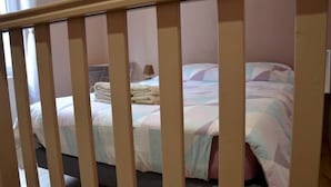 Ein Schlafzimmer mit einem Bett, Kissen und einer zusammengelegten Decke.