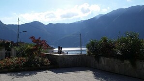 A paved outdoor area with a view of mountains and a body of water. - Gardenia Apartment Ossuccio (Ossuccio)