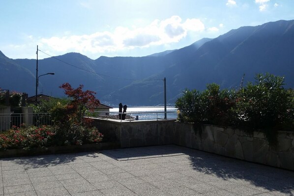A paved outdoor area with a view of mountains and a body of water. - Gardenia Apartment Ossuccio (Ossuccio)