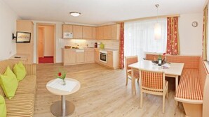 A compact living space with a kitchenette, a dining area, and a seating area. - Tirol apartment with 2 bedrooms (Mayrhofen)