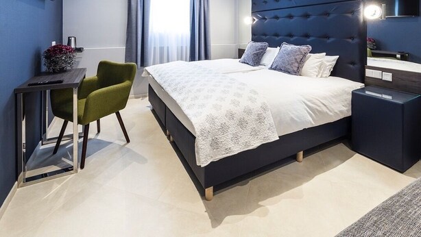 Une chambre à coucher moderne avec un grand lit, un bureau et une chaise.