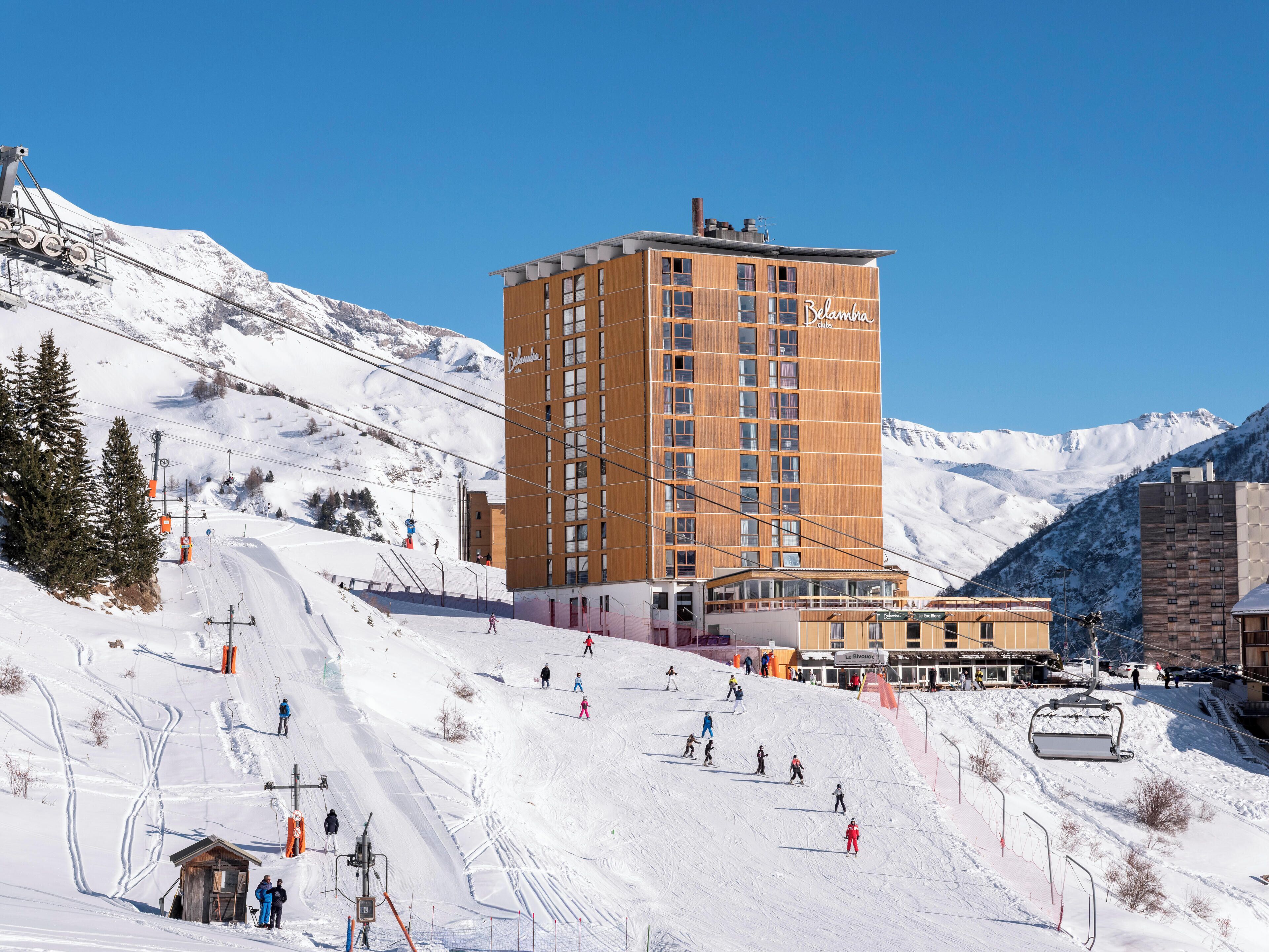 Un hôtel avec une piste de ski en arrière-plan.