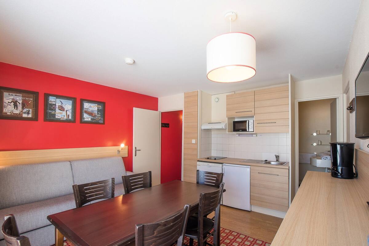 A compact kitchen with a microwave, sink, and a coffee maker.