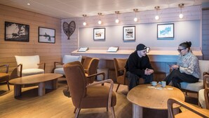A cozy lounge area with wooden walls, a heart-shaped decoration, and framed pictures on the wall. - Belambra Clubs Orcières 1850 - Le Roc Blanc (Orcieres)
