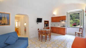 Un espace de vie compact comprenant un coin repas, une kitchenette et un canapé.