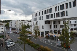 Een modern gebouw met meerdere verdiepingen, een parkeerplaats en een straat met auto's.