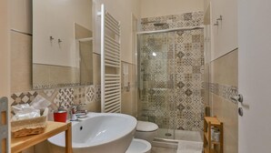 Ein Badezimmer mit einem großen Waschbecken, Toilette und Duschbereich.