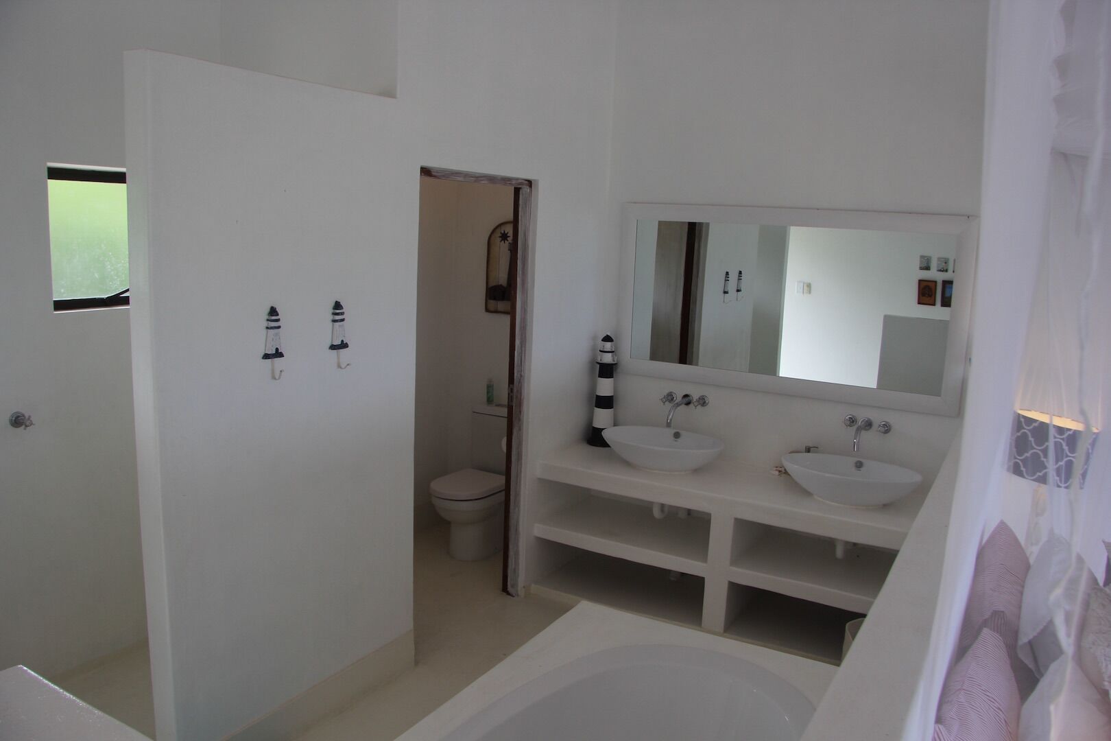 A bathroom with two sinks, a bathtub, and a toilet.