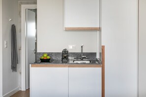 Quarto casal, vista parcial para o mar (701) | Cozinha americana privada | Geladeira, cooktop, máquina de café expresso, cafeteira/chaleira