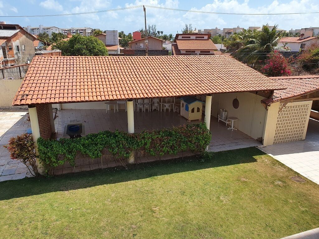 Una casa de un piso con techo de tejas, un pequeño garaje adosado y un jardín delantero con césped y algo de vegetación.