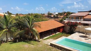 Ein Wohngebiet mit Schwimmbad, überdachter Terrasse und Palmen.