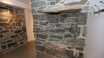 A stone wall with a built-in shelf and hooks on the right side.