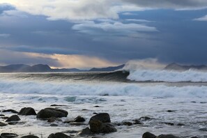 A rocky shoreline with waves crashing against the rocks. - Alnes Gård (Giske)