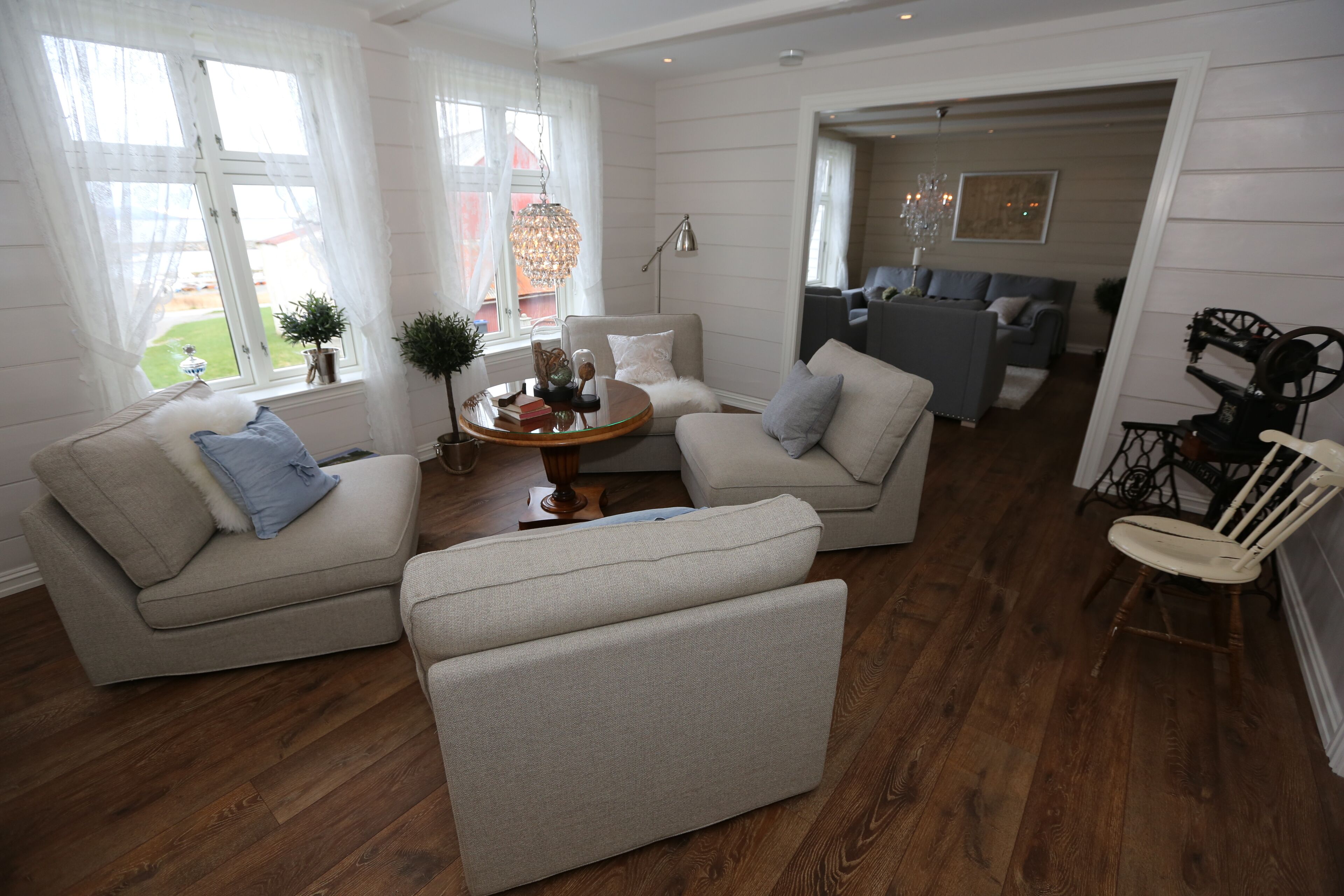 Una sala de estar con sofá, sillón y una mesita con objetos decorativos.
