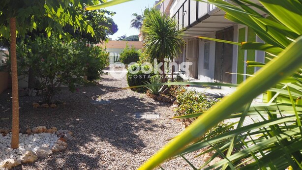 A pathway leading to a building with a covered entrance, surrounded by greenery and a gravel ground. - APARTMENT WITH 3 ROOMS AND LARGE TERRACE, 5 MIN. FROM THE BEACH, IN THE CENTER (Platja d'Aro)