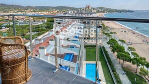 Ett högt hotell med pool, utsikt över stranden och en stadsbild i bakgrunden.