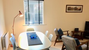 A dining area with a round table, chairs, a bowl, and a lamp. - Modern 2 Bed Apartment in Southampton (Southampton)