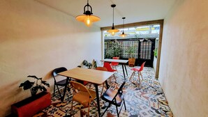 A small dining area with a wooden table and chairs, a patterned floor, and hanging pendant lights. - Casa SAB  Los Andes (Bogotá)