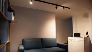 A room with a blue sofa, a white cabinet, and a shelf with books. - Casa SAB  Los Andes (Bogotá)