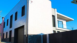 Un edificio moderno con puerta de garaje, fachada de ladrillo y cielo azul despejado.