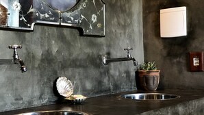A bathroom with two sinks, a potted plant, and a mirror with floral designs. - Convento Arcádia (Barreirinhas)