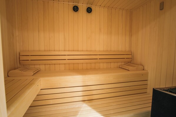 Una sauna de madera con bancos y un asiento.