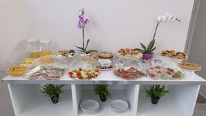 Una mesa de buffet con diversos alimentos y algunas plantas en macetas.