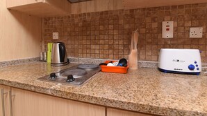 A kitchen with granite countertops, a gas stove, a toaster, and a knife block.