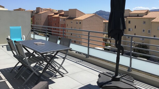A rooftop terrace with a table and chairs, a blue chair, and an umbrella. - Calvi bright T3 top floor 65m2 panoramic view, 4 people, 2 bedrooms, parking (Calvi)