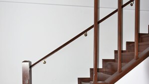 Un escalier en bois, doté d’une rampe, menant à l’étage supérieur.