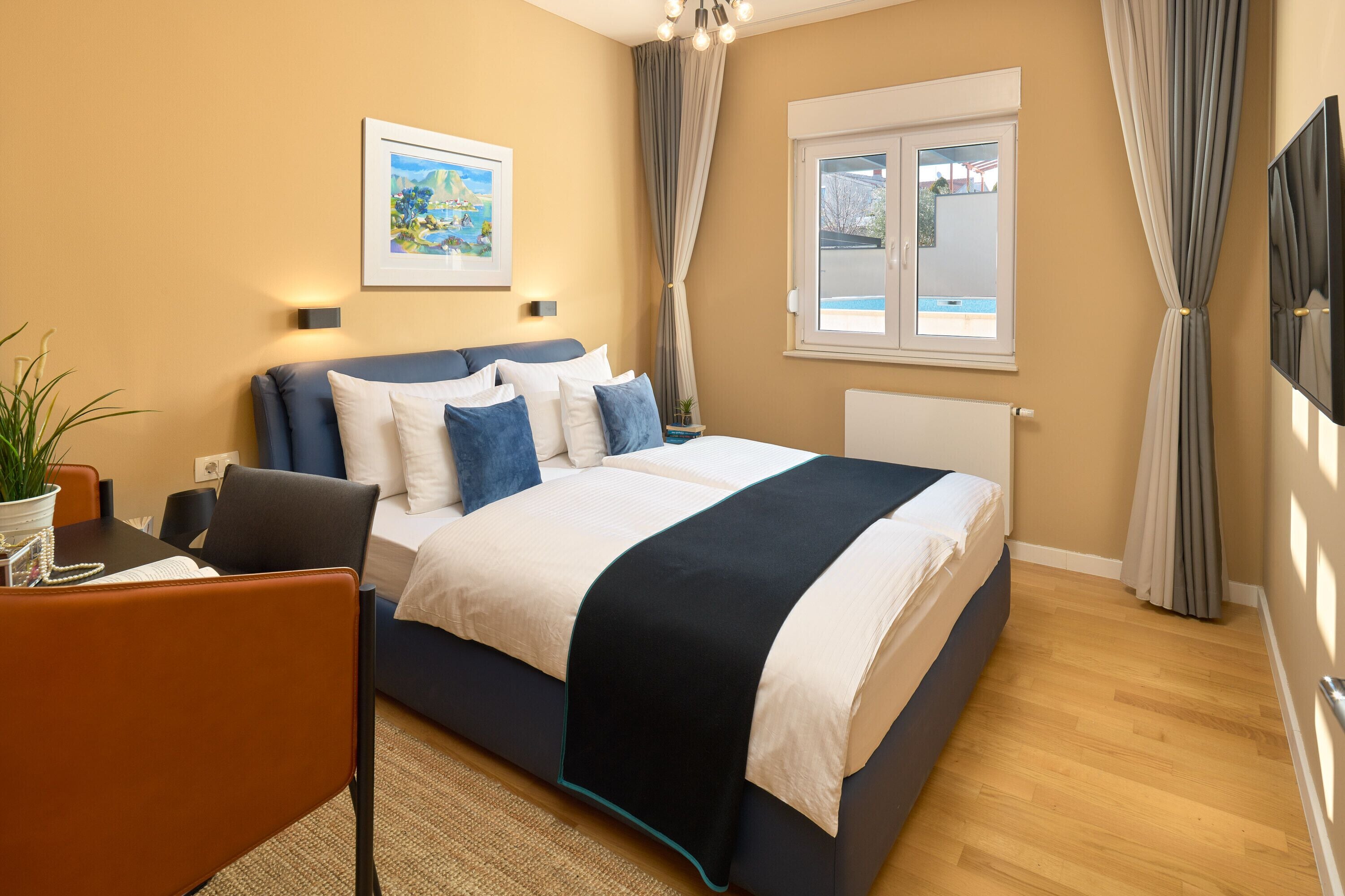 A bedroom with a bed, a desk, and a chair.