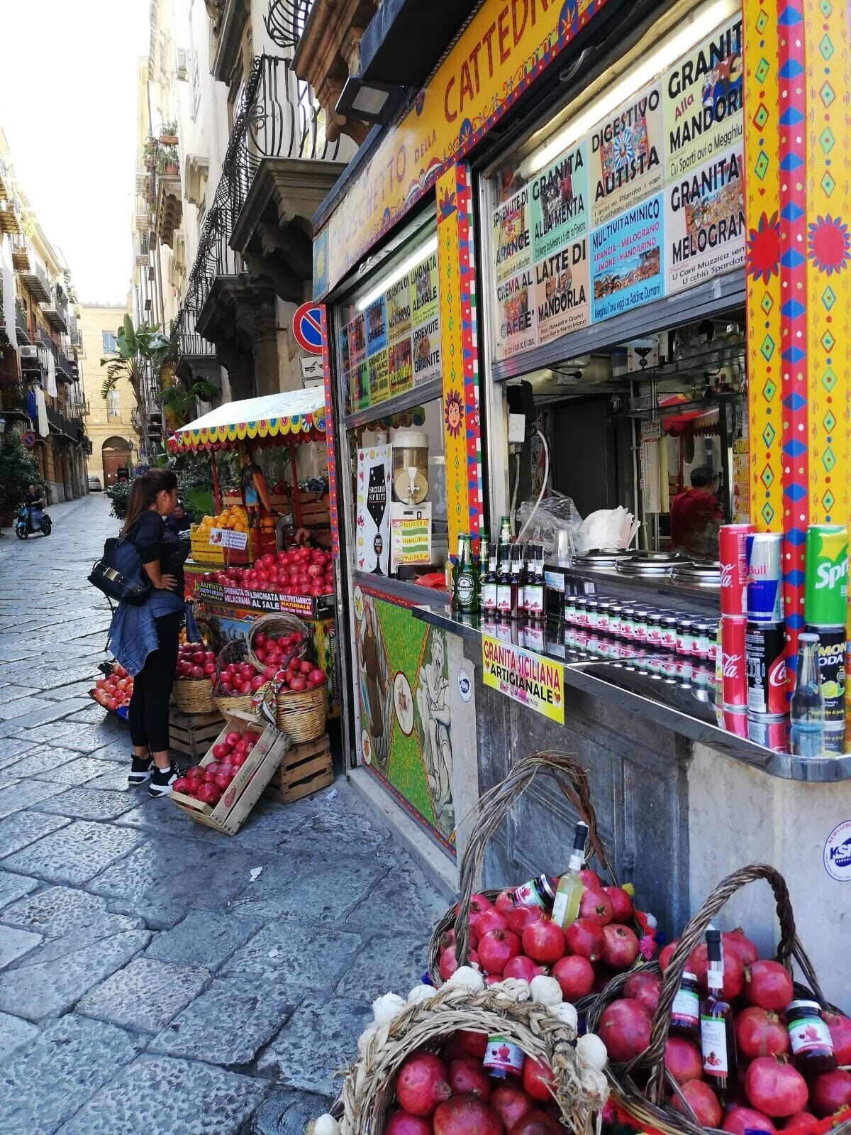 A street food stall with a variety of food items and drinks displayed.