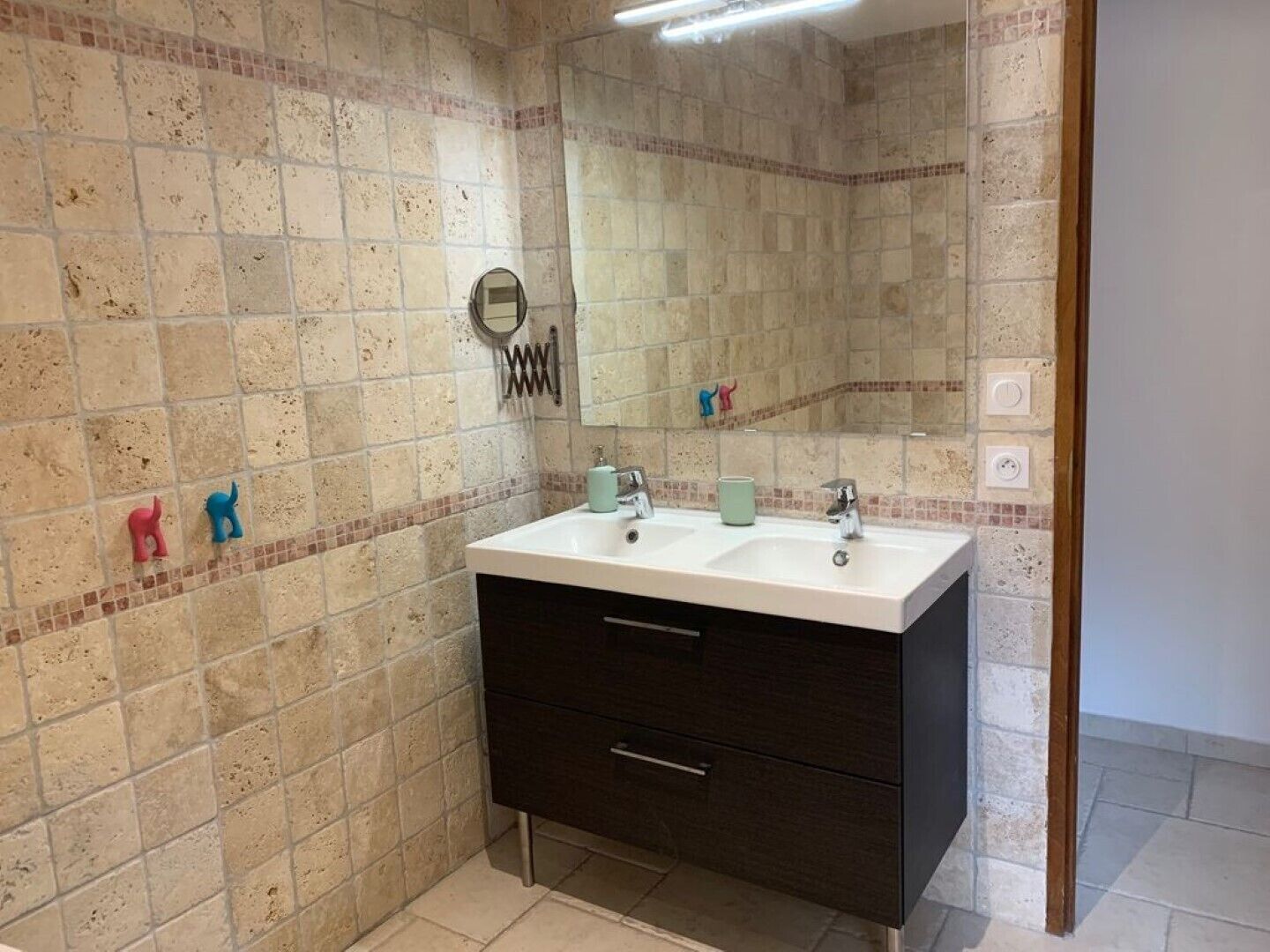 A bathroom with two sinks, a dark cabinet, and a mirror.