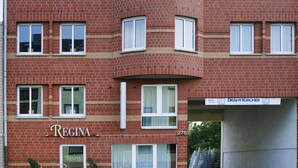 En byggnad i flera våningar, byggd av tegel, med en skylt som visar ordet ”Regina” på bottenvåningen.
