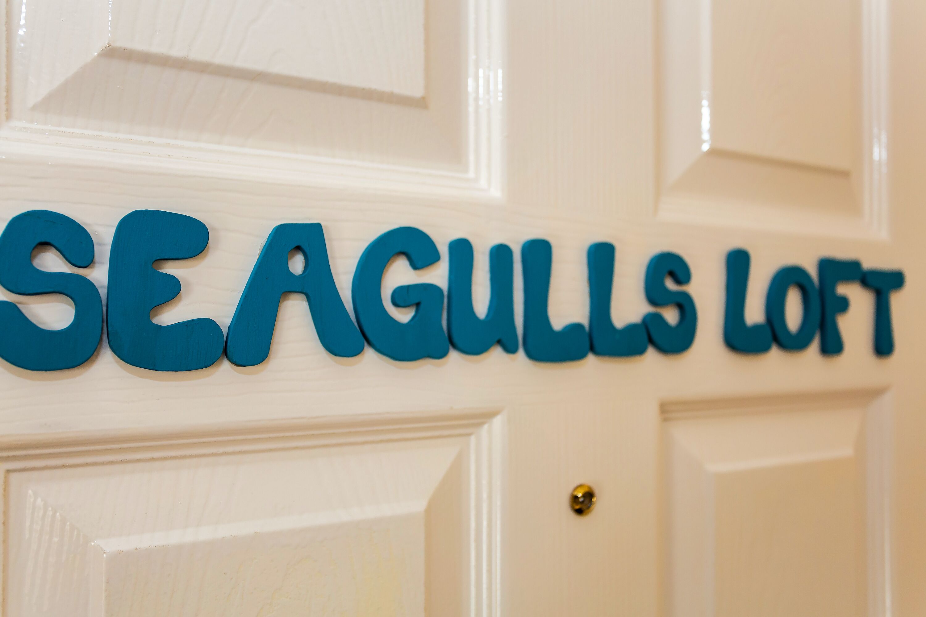 A door with the text "SEAGULLS LOFT" in blue letters.