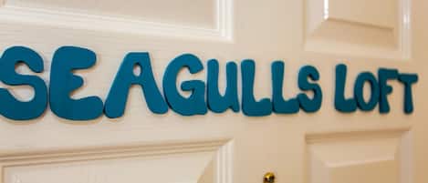 A door with the text "SEAGULLS LOFT" in blue letters.